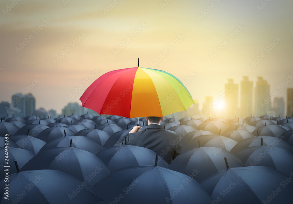 businessman with colorful rainbow umbrella among others, unique different concept - obrazy, fototapety, plakaty 