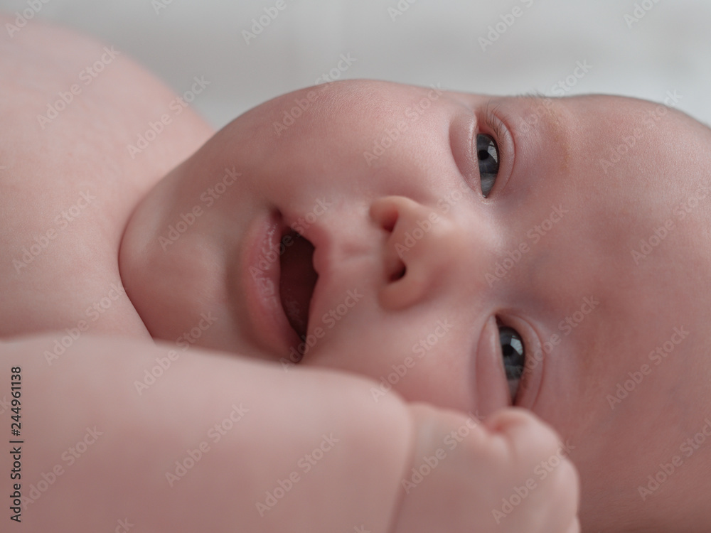 The baby is playfully looking. Baby face close up. The baby is playfully looking. Baby face close up.