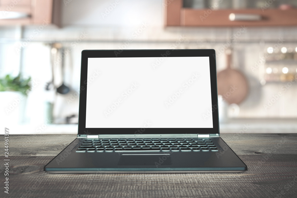 Fototapeta premium Laptop with empty blank screen on wooden tabletop with modern blur kitchen background.