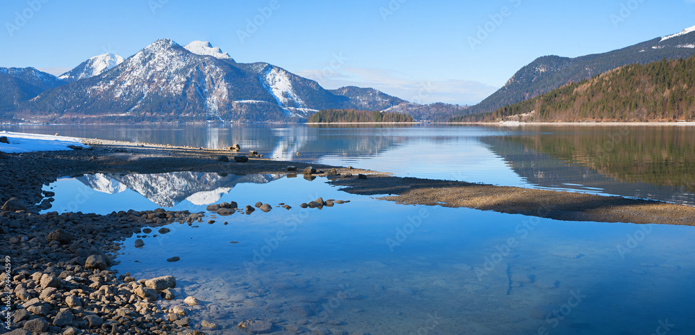 Seeufer Walchensee am Ende des Winters mit Spiegelung der Berge im Wasser Seeufer Walchensee am Ende des Winters mit Spiegelung der Berge im Wasser