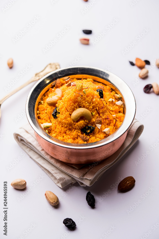 Badaam kesar shira / Sheera or almond saffron halwa, popular Indian dessert served in a bowl. selective focus Badaam kesar shira / Sheera or almond saffron halwa, popular Indian dessert served in a bowl. selective focus