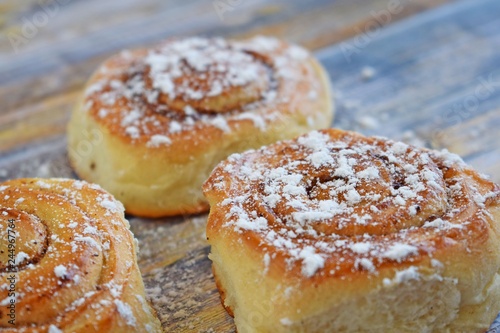 Delicious cinnamon rolls on wooden background.Fresh pastry.