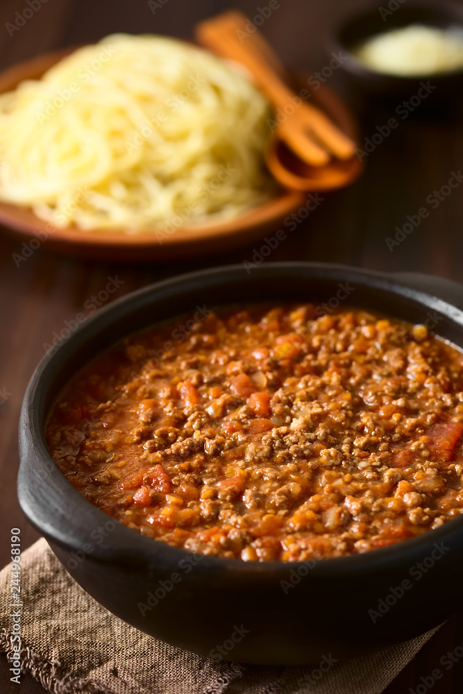Homemade bolognese sauce made of fresh tomatoes, onion, carrot, garlic and mincemeat, photographed on dark wood with natural light (Selective Focus in the middle of the sauce) Homemade bolognese sauce made of fresh tomatoes, onion, carrot, garlic and mincemeat, photographed on dark wood with natural light (Selective Focus in the middle of the sauce)