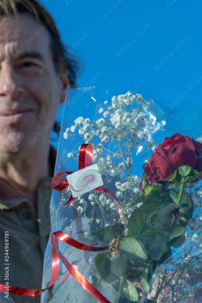 Homme sénior tenant un bouquet de fleurs avec des roses rouges pour offrir  un cadeau d'amour Stock Photo | Adobe Stock