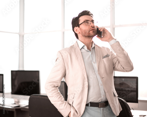 serious businessman talking on smartphone phone in empty office