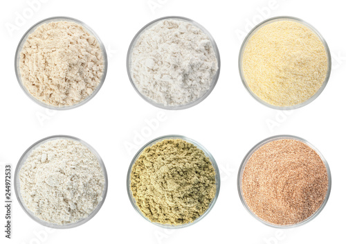 Set of organic flour in glass bowls on white background, top view