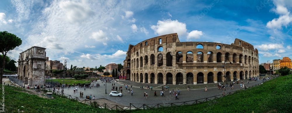 panoramic view on Colloseum and Arch of Constantine with los of tourists during cloudy day in Rome, Italy