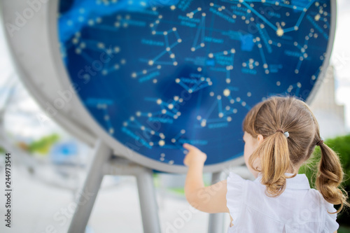 MOSCOW, RUSSIA - JULY 6: Exhibition in Moscow Planetarium. Little girl looking at the exhibits of the one of the world`s largest planetarium, star chart photo