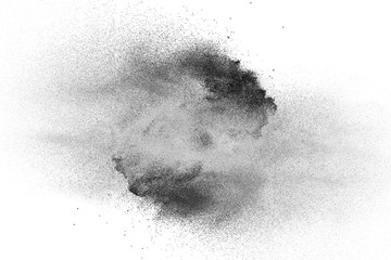 Black powder explosion on white background.Black dust particles splash.