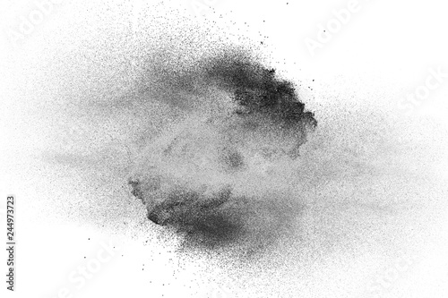 Black powder explosion on white background.Black dust particles splash.