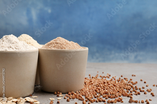 Composition with different types of flour on table against color background. Space for text