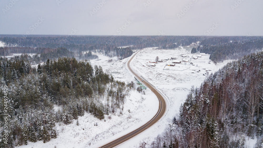 Aerial view of country road going through the beautiful snow covered landscapes. Aerial view of country road going through the beautiful snow covered landscapes.