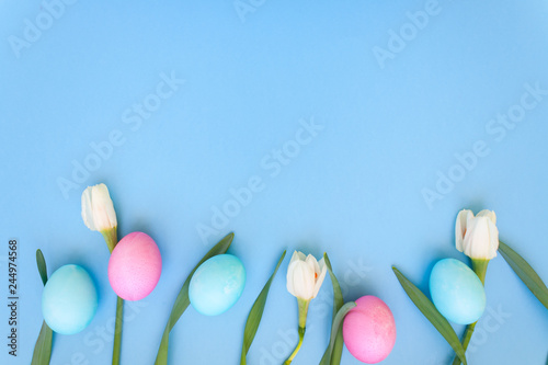 Easter eggs and spring flowers on blue background
