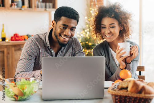 Young couple using laptop to look up recipe