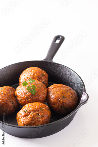 Food Homemade raw organic spicy meatball in iron cast on white background