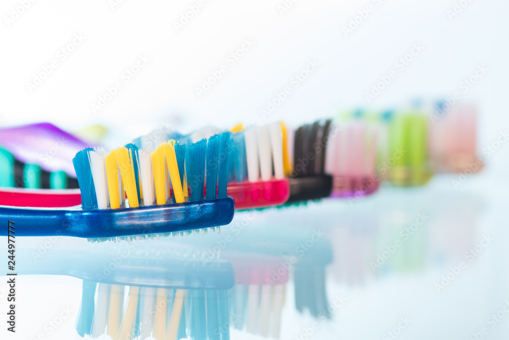 Several toothbrushes one by one next to the toothpaste Several toothbrushes one by one next to the toothpaste