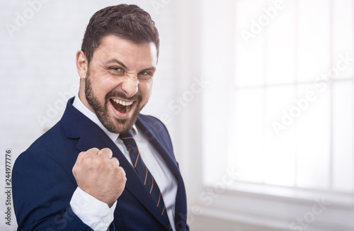 Businessman celebrating victory shouting happily in office