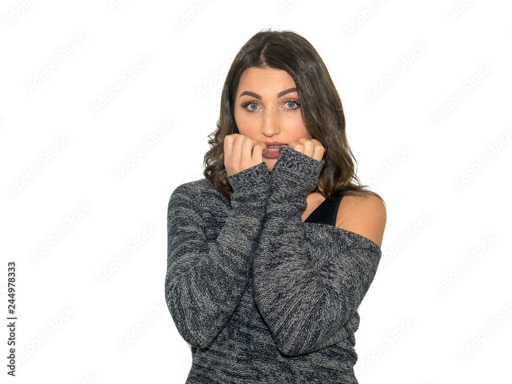 beautiful young girl with dark hair is nervous and bites nails, studio photo isolated on a white background beautiful young girl with dark hair is nervous and bites nails, studio photo isolated on a white background