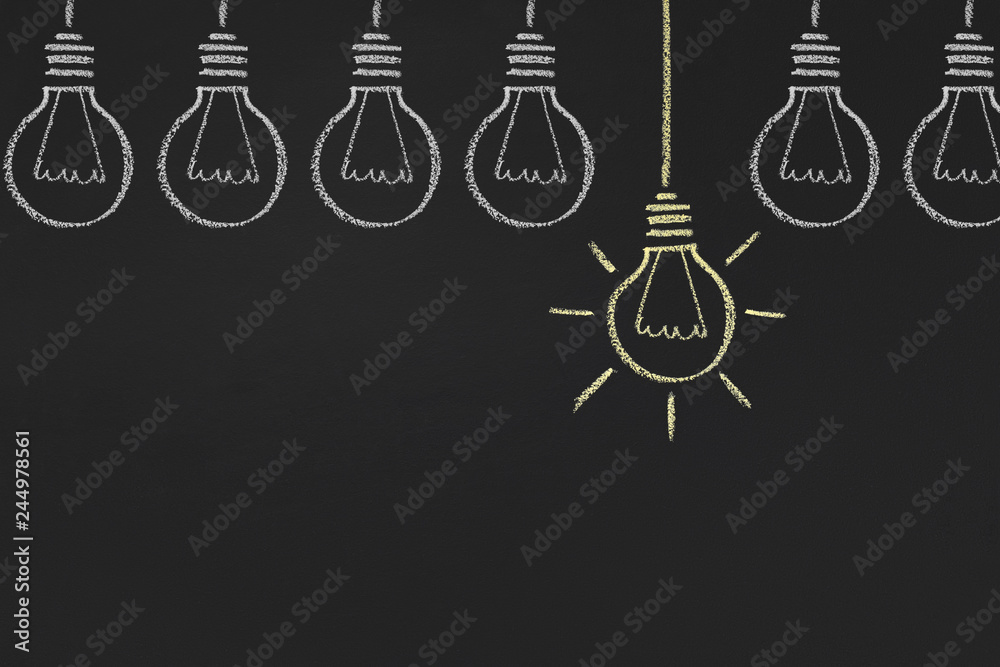 One glowing yellow light bulb between white, copy space