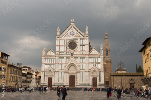 Facade of Basilica Santa Croce with rainy clouds on background. Florence, Tuscany, Italy.