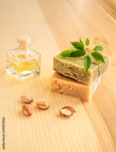Bottles with cosmetic oil argan nuts. Cosmetic means. Food product. Jar with argan oil and handmade soap on the wooden background