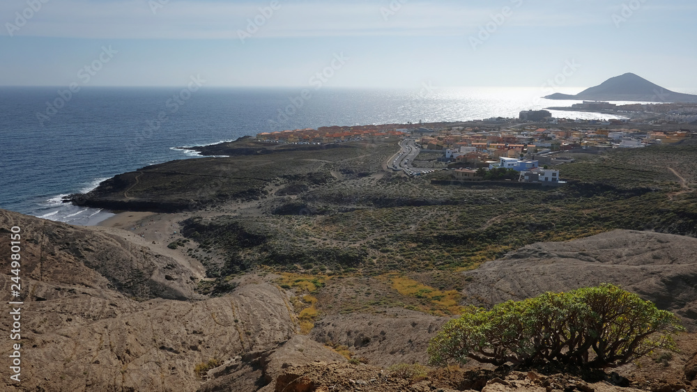 Elevated views from Pelada Mountain, locally known as Montana Pelada towards the windsurfing coastal town of El Medano and with Montana Roja at the far end, in Tenerife, Canary Islands, Spain