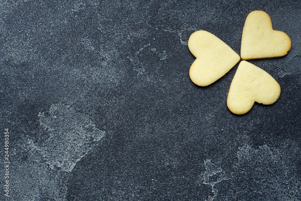 Obraz premium Shamrock cookies in the shape of a heart on a dark background.