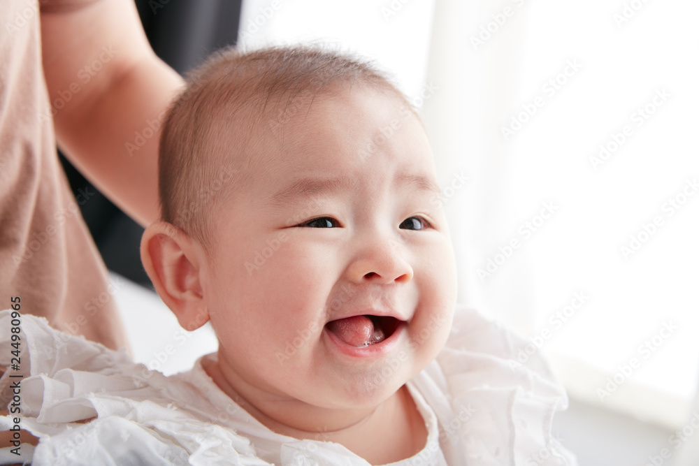 Asian young mother holding a baby in her arms
Asian young mother holding a baby in her arms