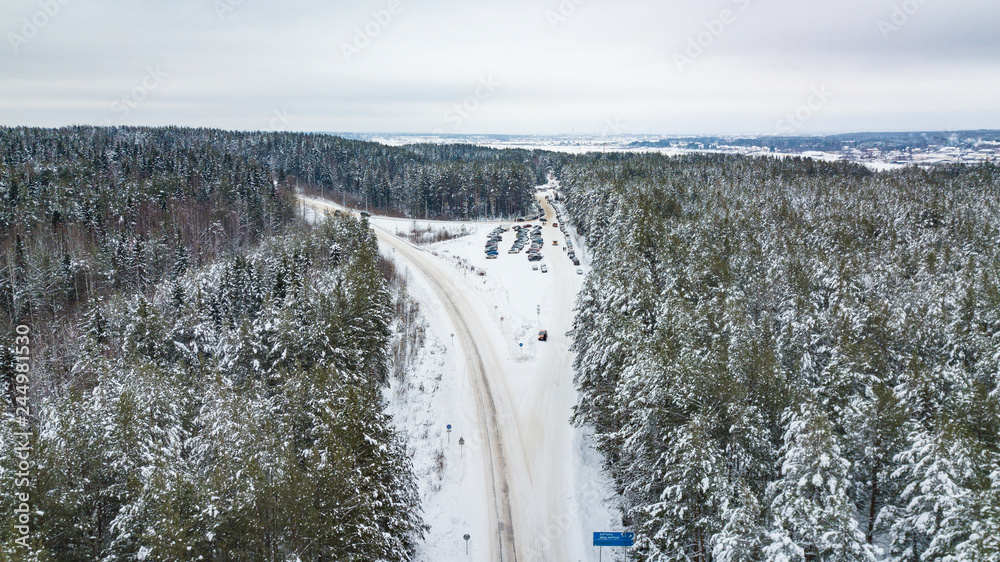 Aerial view of forest covered with snow, road in winter time Aerial view of forest covered with snow, road in winter time