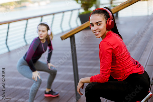 Two young women practice stretching outdoor © BGStock72