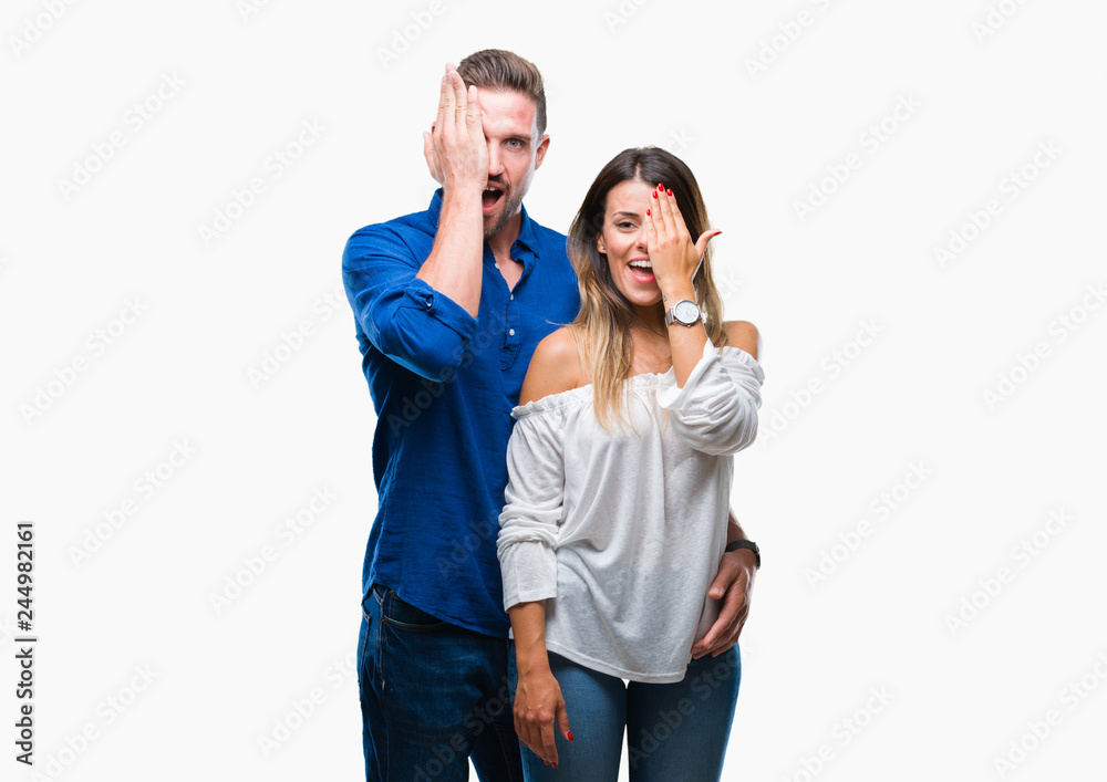 Young couple in love over isolated background covering one eye with hand with confident smile on face and surprise emotion. Young couple in love over isolated background covering one eye with hand with confident smile on face and surprise emotion.