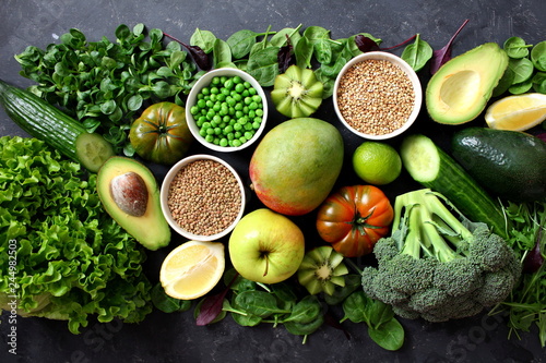 Clean eating selection Protein source for vegetarian: avocado, apple, broccoli, spinach, green peans on dark background. Healthy green food. Top view with copy space. Diet food. photo