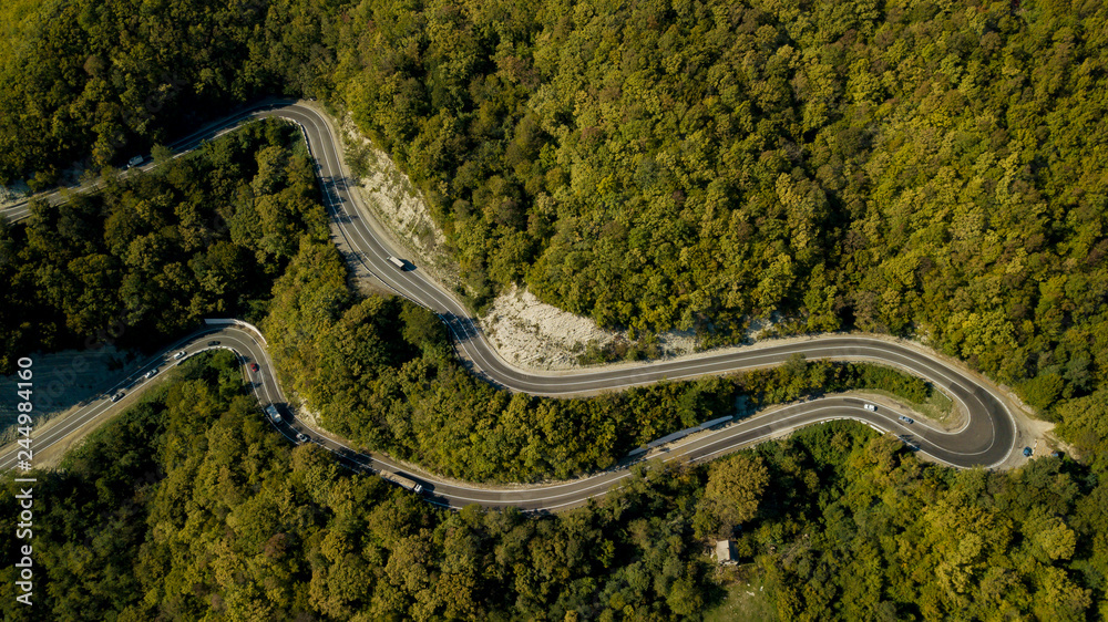 Aerial view of a curved winding road trough the forest. Sochi, South Russia.