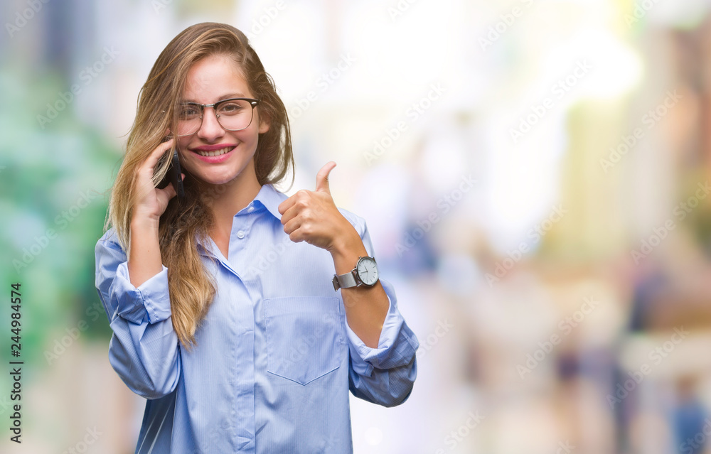 Young beautiful blonde business woman calling using smartphone over isolated background happy with big smile doing ok sign, thumb up with fingers, excellent sign