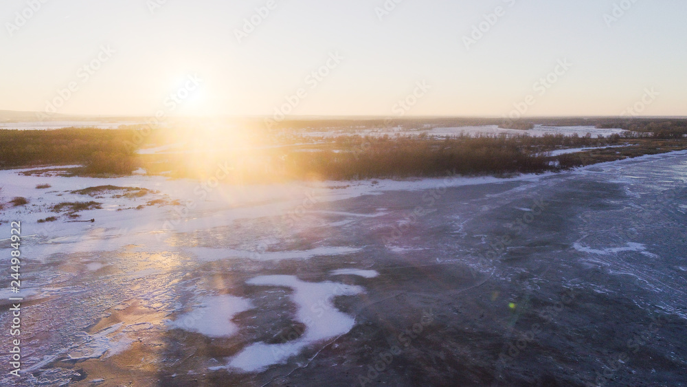 sunset with frozen ice river and leans flare , drone shoot sunset with frozen ice river and leans flare , drone shoot