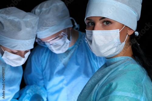 Closeup of surgeons performing operation. Focus on female nurse. Medicine  surgery and emergency help concepts