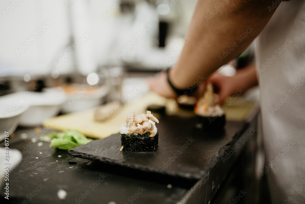Fototapeta premium A close up shot of a chef making sushi. Concept of Japanese cultural cuisine, food and hospitality.