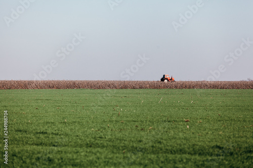 Red tractor rides field