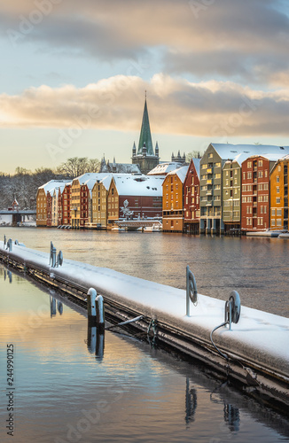 Old houses and magazines by Nidelva river in Trondheim, Nidarosdomen Cathedral in back.