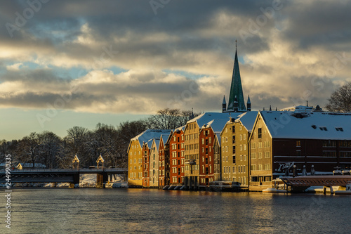 Old houses and magazines by Nidelva river in Trondheim, Nidarosdomen Cathedral in back.