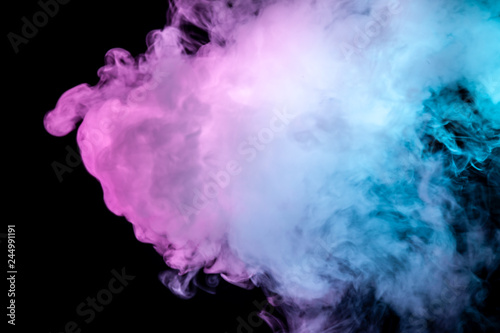 Multicolor, thick smoke, illuminated by colored in blue, purple and pink light against a dark black isolated background, welded with clubs and curls, rising from a steam of vape. Wind blow