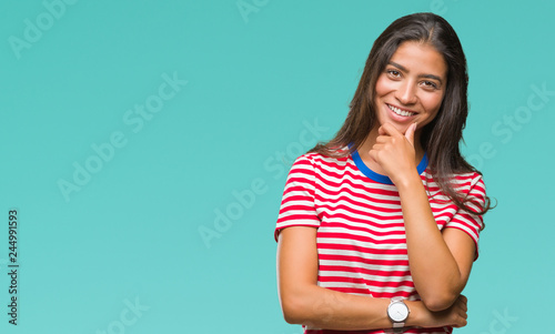 Young beautiful arab woman over isolated background looking confident at the camera with smile with crossed arms and hand raised on chin. Thinking positive. © Krakenimages.com