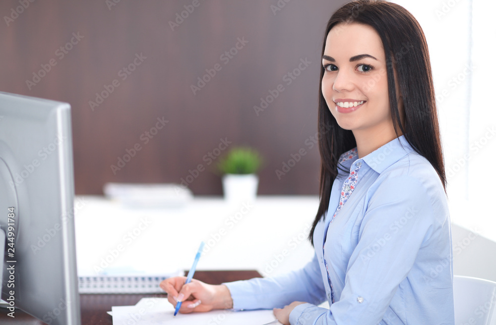 Young brunette business woman looks like a student girl working in office. Hispanic or latin american girl happy at work and too busy Young brunette business woman looks like a student girl working in office. Hispanic or latin american girl happy at work and too busy