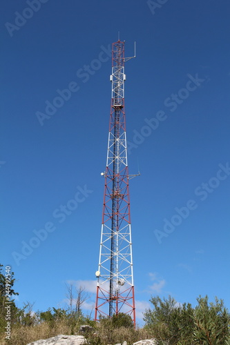 Red and white lattice telecommunications mast.
