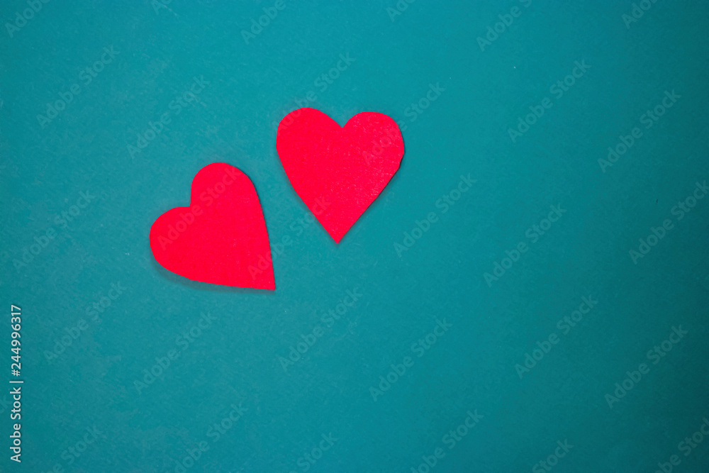 Two red decorative hearts on green background. Valentine's Day Concept. Two red decorative hearts on green background. Valentine's Day Concept.