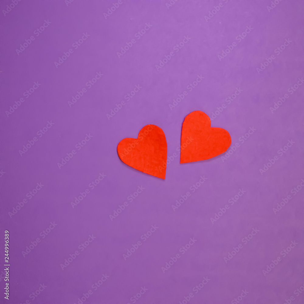 Two red decorative hearts on purple background. Valentine's Day Concept. Two red decorative hearts on purple background. Valentine's Day Concept.
