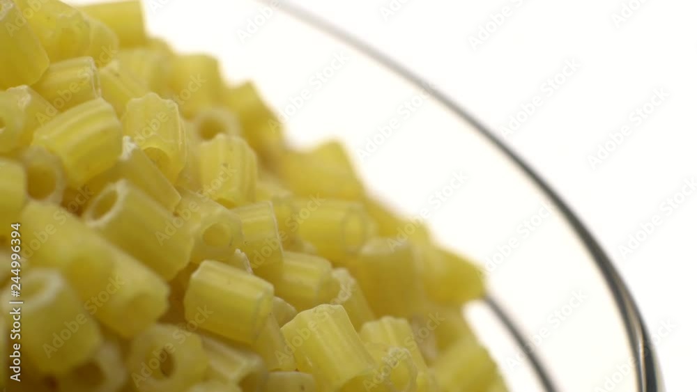 Raw macaroni in rotation. Ditalini lisci. Close up. Raw pasta isolated on white. Italian cuisine concept. Ditalini, Ditalini lisci, piccoli lisci, Raw macaroni in rotation. Ditalini lisci. Close up. Raw pasta isolated on white. Italian cuisine concept. Ditalini, Ditalini lisci, piccoli lisci,