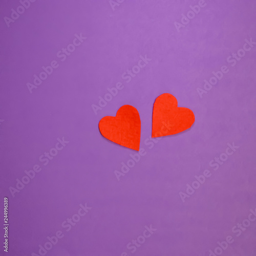 Two red decorative hearts on purple background. Valentine's Day Concept.