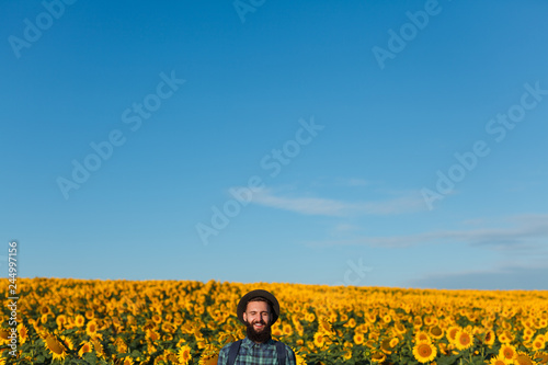 Cheerful man near sunflower field