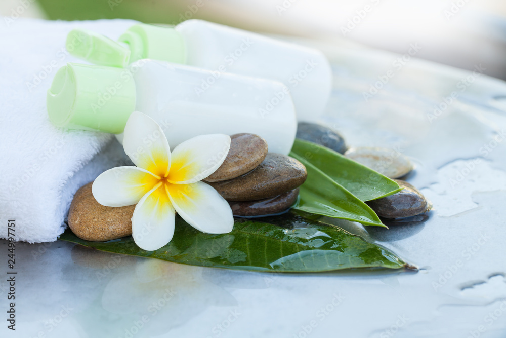 Two bottle on the white towel, flower and stones Two bottle on the white towel, flower and stones